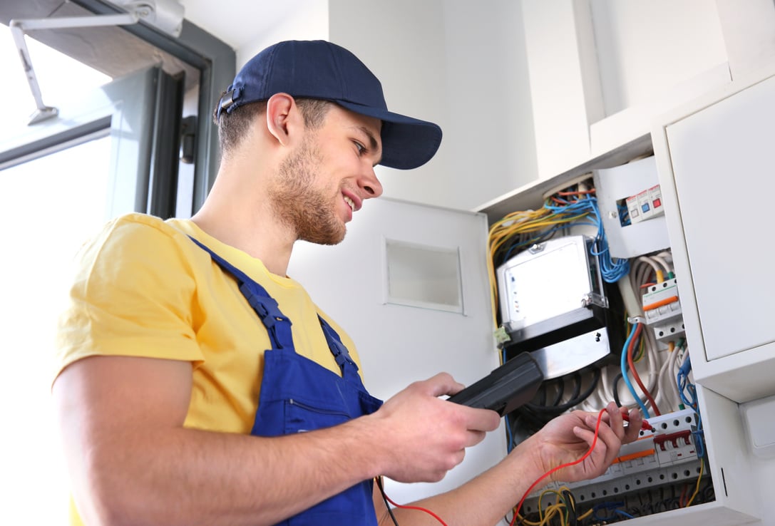 Electrician Measuring Voltage in Distribution Board